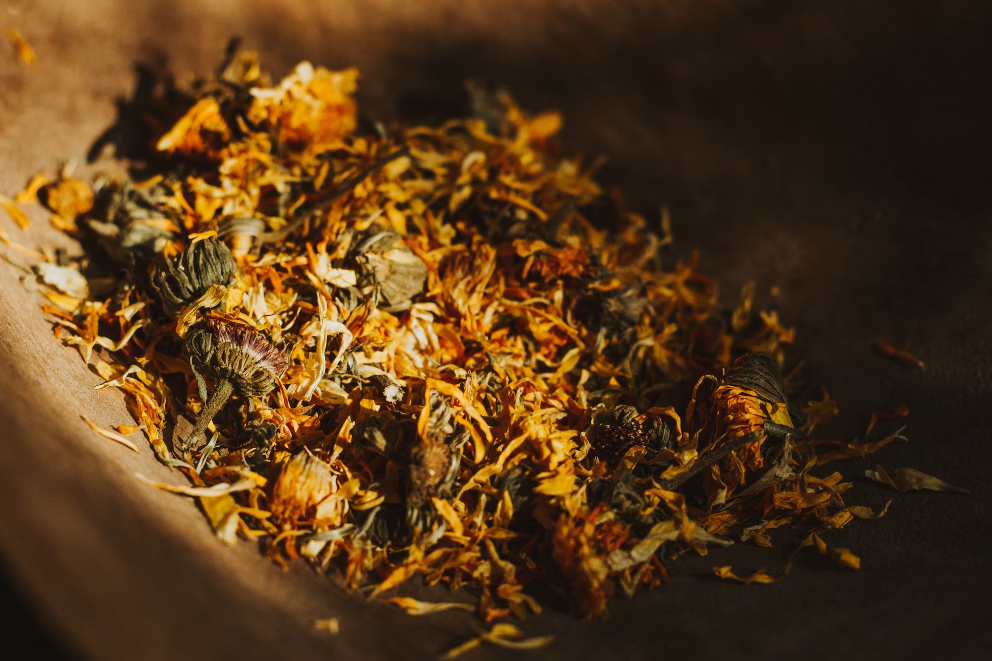 Dried herbs and flowers in a wooden bowl