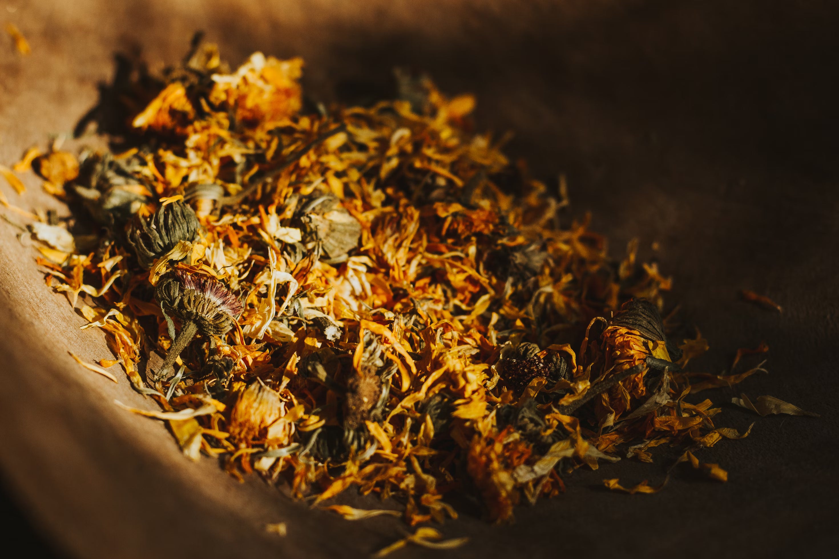 Dried herbs and flowers in a wooden bowl