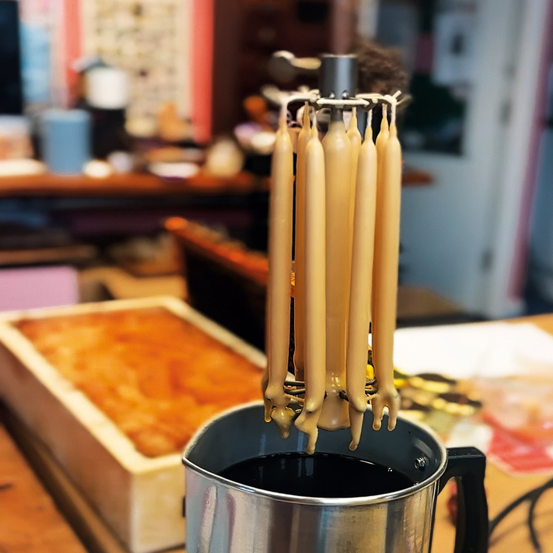 Candle-making process with wicks in a pot of wax