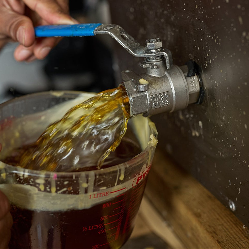 pouring british beeswax from big melter into a pyrex jug